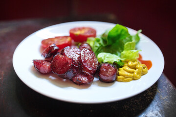 Sliced grilled sausages (Asian style) on white dish