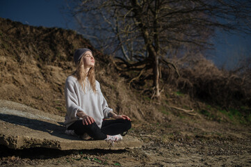 Practice of meditation and interaction with nature. Girl near river