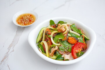 Mixed dried fish with young neem leaves, sliced green mango and sliced tomato - Vietnamese style salad