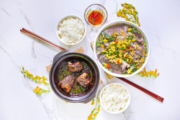 Family lunch set for 2 people with sour fish soup, stew fish in clay pot and rice
