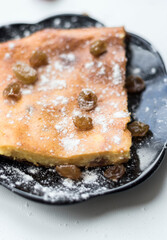 Appetizing curd casserole. Nearby is a drink and raspberries with raisins.