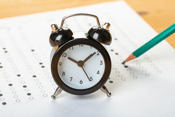 alarm clock, optical form of standardized school test with bubble and black pencil, answer sheet, education concept