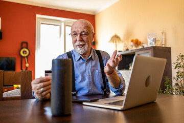 Senior man using Virtual Assistant at home
