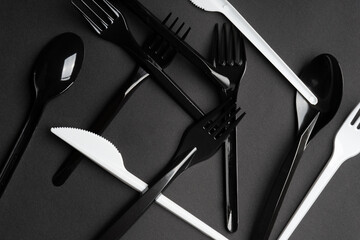 Forks and spoons on gray background. Plastic cutlery, ecology, environmental pollution by plastic, disposable tableware, waste recycling concept. copyspace, flat lay