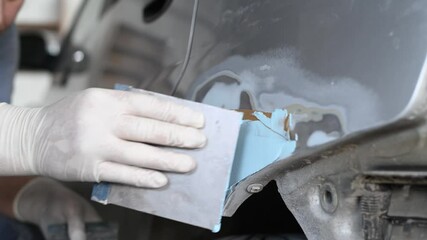 auto body repair or refinishing. Plastering the car detail before painting