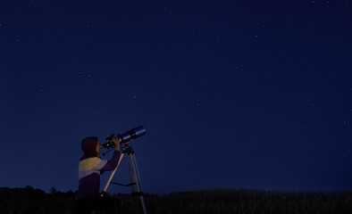 Telescope and stars. Woman looks through an optical telescope at a starry sky. Stargazing, night sky, astronomy