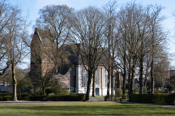 Fototapeta na wymiar Reformed church in the small village Bathmen, Overijssel in the Netherlands with bare trees in spring