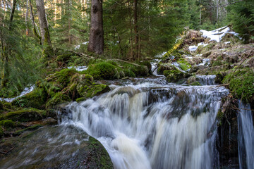 Cascade falls over mossy rocks