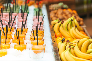 Row of healthy fresh fruit and vegetable smoothies with assorted ingredients.