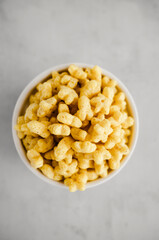 Honey oat stars breakfast cereal in white bow. Healthy whole grain taste. Top view. 