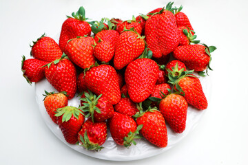 Ripe, red, fresh strawberries on White Plate. Organic fresh strawberry from garden. Plate with juicy strawberries on white background.