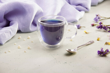 Composition with cup of blue tea, napkin air folds and beads