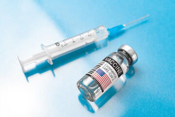 American COVID-19 vaccine with syringe, vaccination concept, laboratory background with glass table