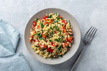 Traditional salad Tabouleh with bulgur on concrete background, top view