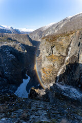 Norwegian Voringfossen waterfall in early spring, leftover ice left over from winter in the Mabodalen valley in the Eidfjord municipality.