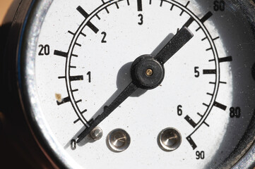 A close-up of a part of the white dial of an old manometer with an arrow at zero. Production stop...