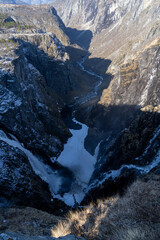 Norwegian Voringfossen waterfall in early spring, leftover ice left over from winter in the Mabodalen valley in the Eidfjord municipality.