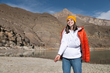 Portrait of a Traveler. Women hiking woman happy and smiling while hiking in the mountains. Puts the jacket over his shoulders