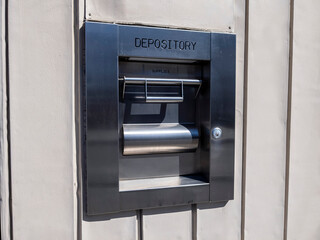 View of a metal depository box on the outside of a bank