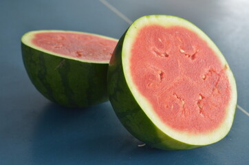 whole and half watermelon isolated in blue background