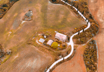 Aerial view of Monticchiello zigzag cypress road from drone in Tuscany, spring season