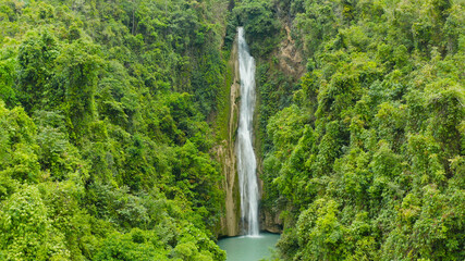 Beautiful waterfall in green forest, top view. Tropical Mantayupan Falls in mountain jungle, Philippines, Cebu. Waterfall in the tropical forest.