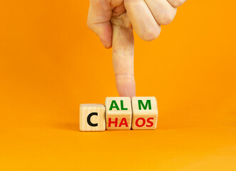 Stop chaos, time to calm symbol. Businessman turns wooden cubes and changes the word 'chaos' to 'calm'. Beautiful orange background, copy space. Business and chaos or calm concept.