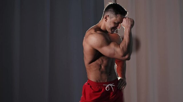 Sports training - athletic muscular shirtless man posing and showing his muscles