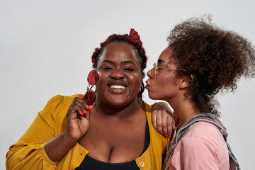 Fototapeta premium Picture of an afro women kissing second into the cheek 