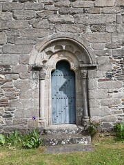 Fototapeta na wymiar Puerta lateral, con arco de medio punto, de la iglesia románica de Baamonde, Galicia
