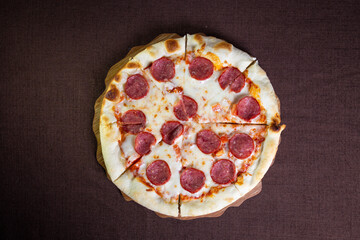 View from the top of the pizza peppnroni on a brown background
