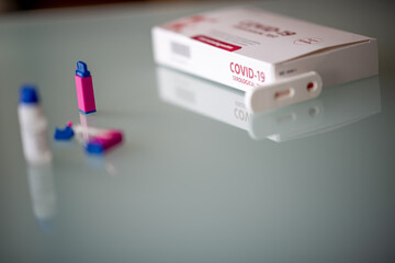 Fototapeta premium Covid-19 test Antibody test on Covid. Pipette, test cassette, green lancet box placed on a reflective table