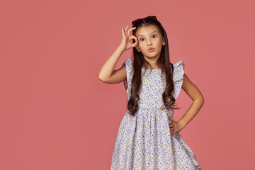 child girl in summer dress showing Ok gesture