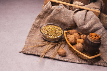 Walnuts, almonds, wheat grains and ears of corn lie on burlap. Alternative sources of protein and vitamins in food. Vegetarian food.