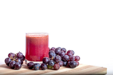 Grape juice in a glass on the table against a white background.
