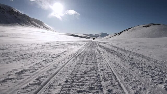 Riding a snowmobile - snow scooter travel in polar circle, Arctic Svalbard. Fast motion pov point-of-view, front mounted of snowmobiling adventure time-lapse.