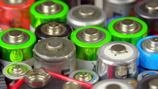 lots of old used batteries, top view. Different types of batteries and batteries rotate on the turntable. Movement.
