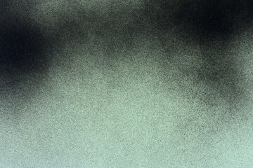 black spray paint on a soft green colored paper background
