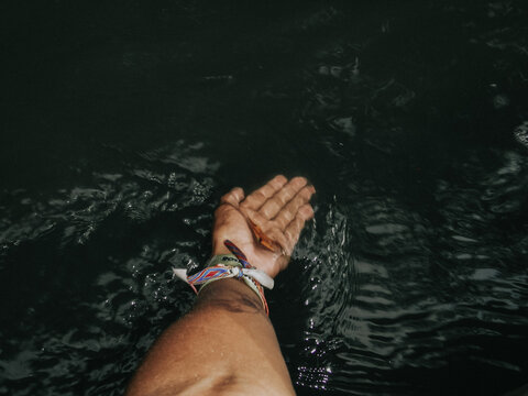 Hand in passing water with bracelets
