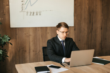 Successful businessman working at a laptop in the office.