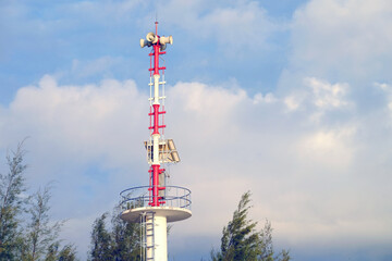 Surrounded megaphone at the top of observation tower with cloudy sky background