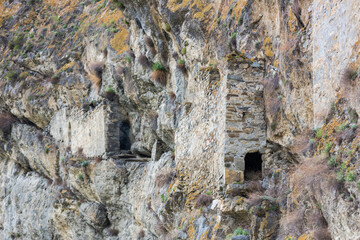 Ancient dwellings in the mountains. Kurtat Gorge in North Ossetia-Alania, Russia. Stone cave houses in the rocks. Dzivgis village in Fiagdon