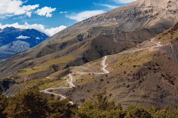 Panoramic view of Table Mountain in Ingushetia, Russia. Mountain serpentine road. Landscape, rocks and blue sky. The road to the top. Mountain climbing. Tourist adventure.