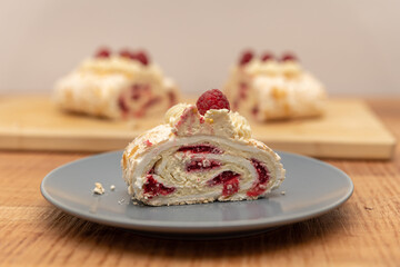 A piece of merengue cake with raspberries, lies on a plate