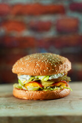 Rustic handmade hamburger on a brick wall background.