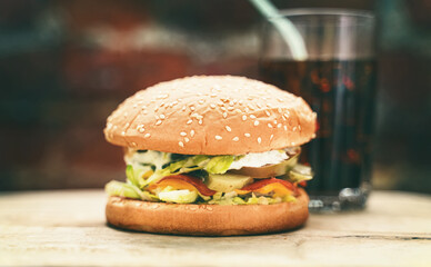 Rustic handmade hamburger on a brick wall background.