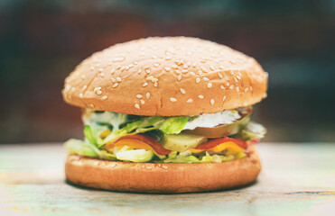 Rustic handmade hamburger on a brick wall background.