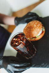 Rustic handmade hamburger and cola on the table.