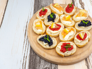 wooden plate with bruschetta with assorted fish roe