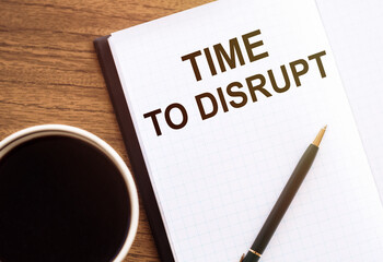 TIME TO DISRUPT - text on notepad on wooden desk.